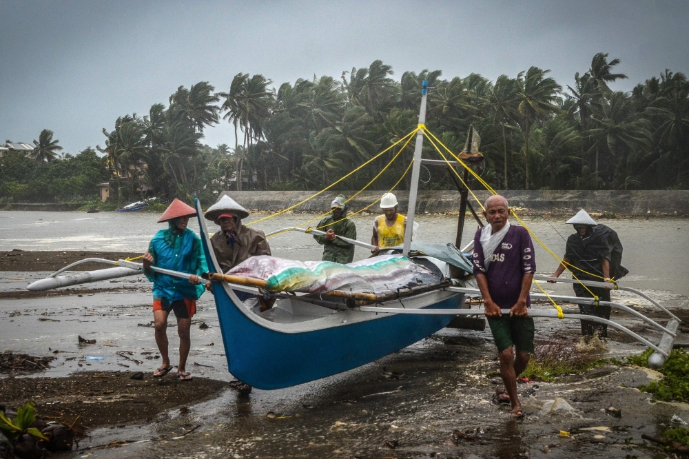 Fishermen carry a boat to higher ground in Baybay, eastern Samar on December 24, 2019, after typhoon Phanfone hit the central Philippines.   AFP / Alren BERONIO