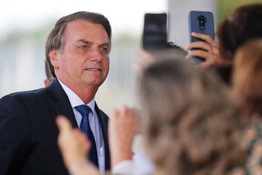 Brazil's President Jair Bolsonaro poses for pictures as he leaves the Alvorada Palace in Brasilia, Brazil December 12, 2019. REUTERS/Adriano Machado