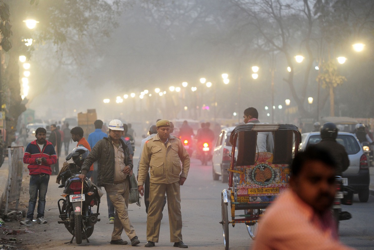 Indian policemen stand as traffic passes through the Civil Lines area of Allahabad on December 14, 2016. AFP / Sanjay Kanojia
 