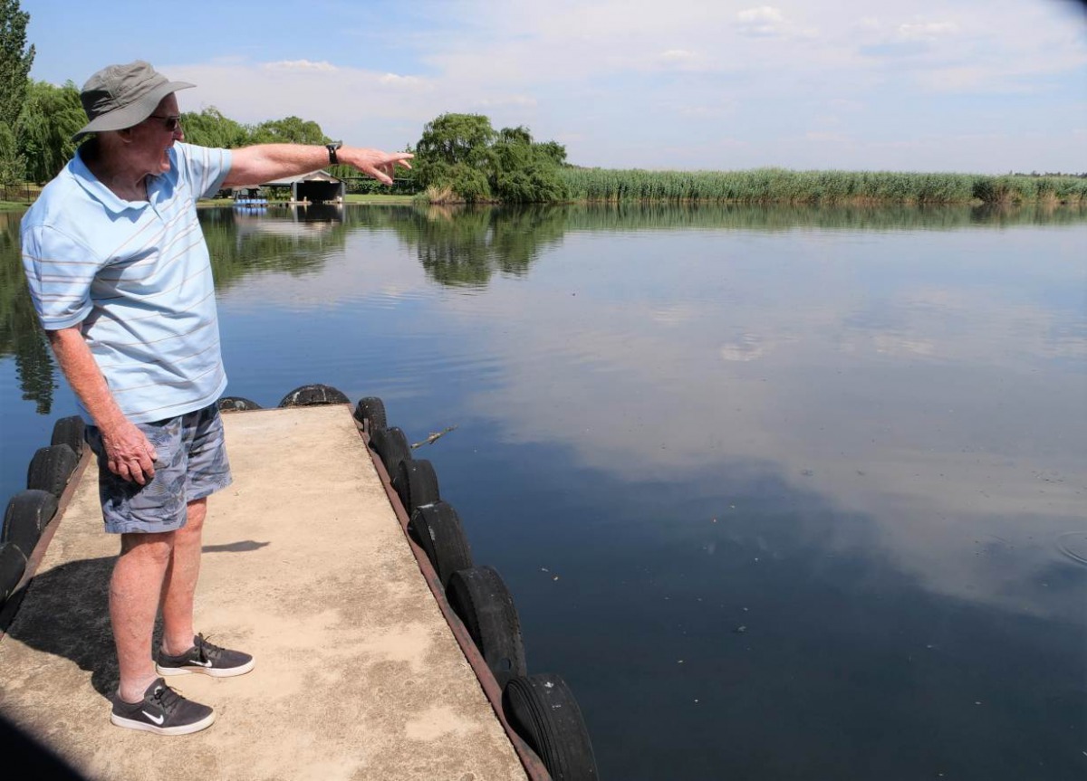 Mike Gaade from water rights organisation SAVE, points to water in the distance from his home in Lochvaal, South Africa, 29 November 2019. Thomson Reuters Foundation/ Kim Harrisberg