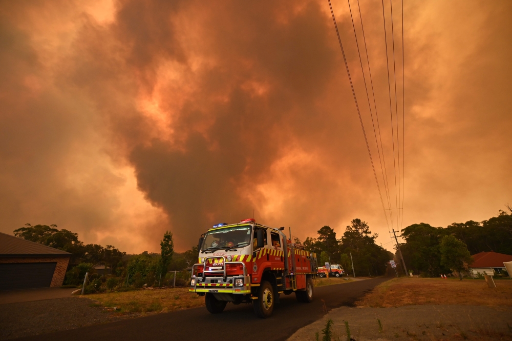 Firetrucks are seen stationed on a road as a bushfire burns in Bargo, southwest of Sydney on December 21, 2019. (AFP / PETER PARKS)