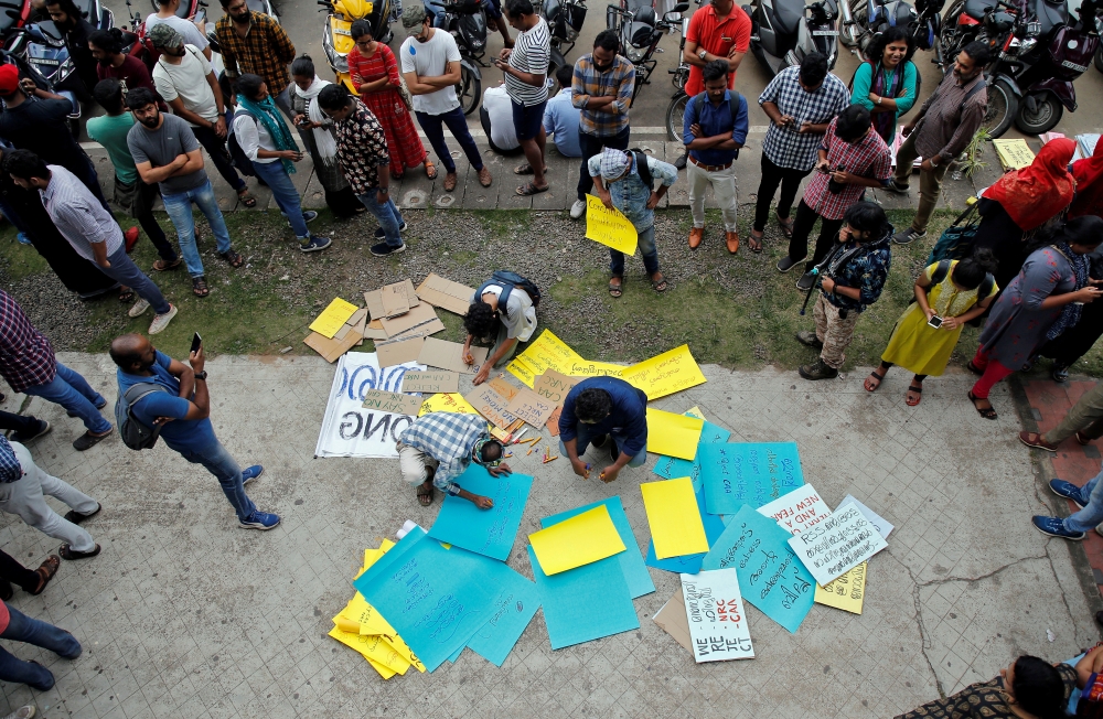 Demonstrators prepare placards before attending a protest march against a new citizenship law, in Kochi, India, December 23, 2019. (REUTERS/Sivaram V)