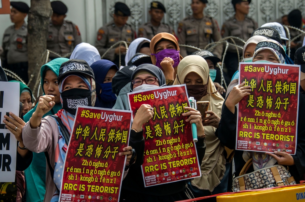 Indonesian hardline Muslim group members take part in an anti-China rally in front of the Chinese colsulate in Surabaya, East Java, on December 27, 2019, to condemn China's government for rounding up an estimated one million Uighurs and other mostly Musli