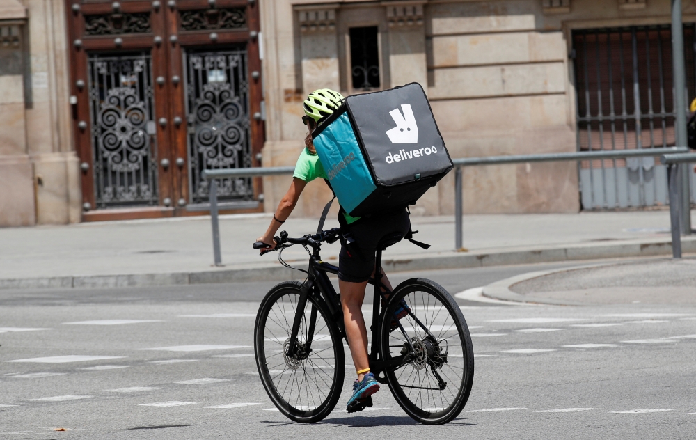 A biker wearing a Deliveroo backpack drives in the central Barcelona, Spain, July 23, 2019. Reuters/Albert Gea