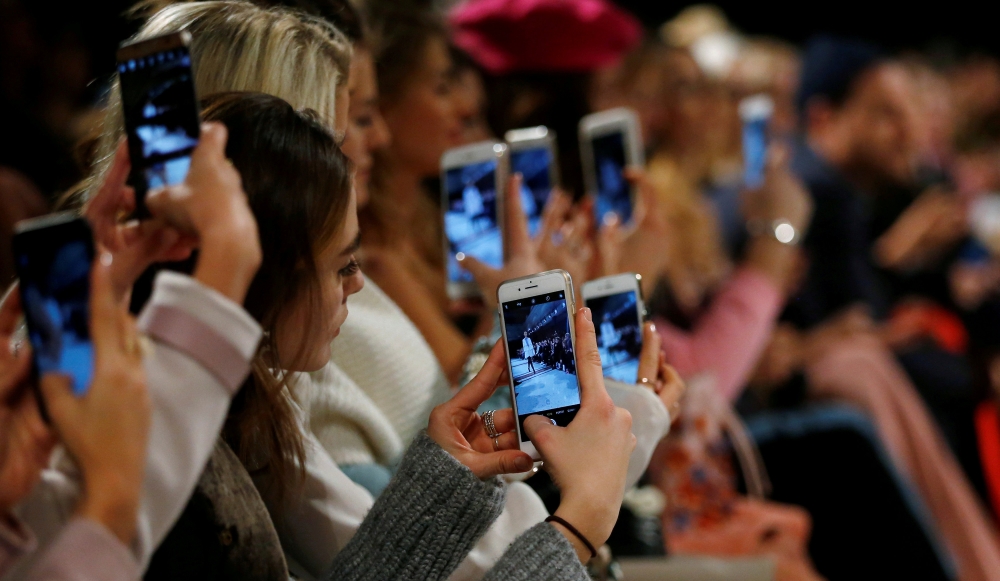 A so-called media influencer takes pictures at Berlin Fashion Week, January 19, 2017. Reuters / Hannibal Hanschke