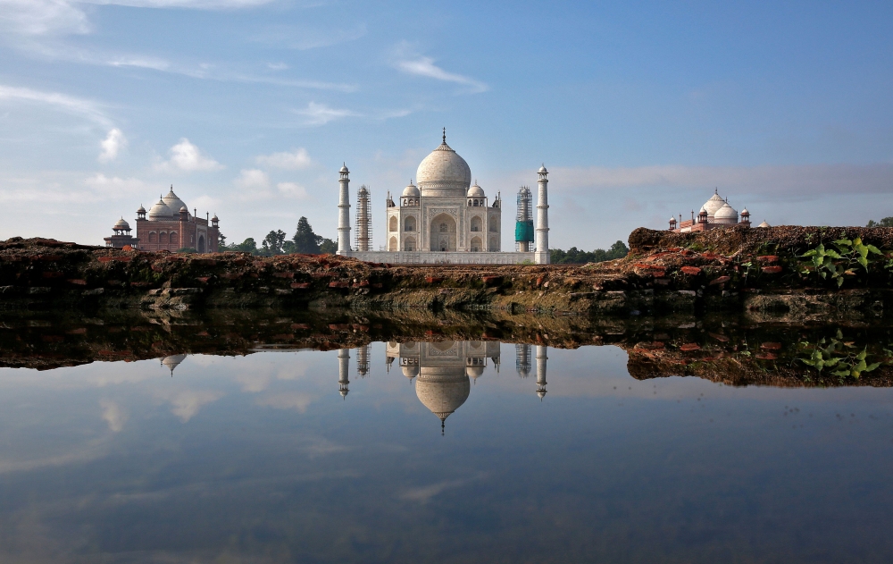 The Taj Mahal is reflected in a puddle in Agra, India August 9, 2016. REUTERS/Cathal McNaughton/File Photo
