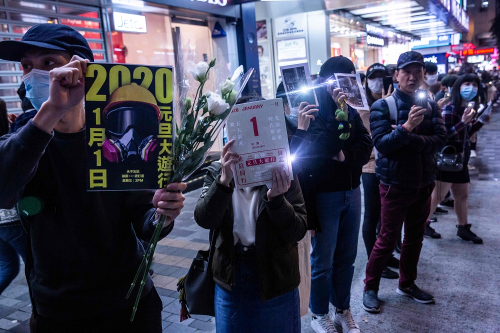 Protesters take part in a human chain rally at the Tsim Sha Tsui district of Hong Kong on December 31, 2019.  AFP / Isaac Lawrence
 