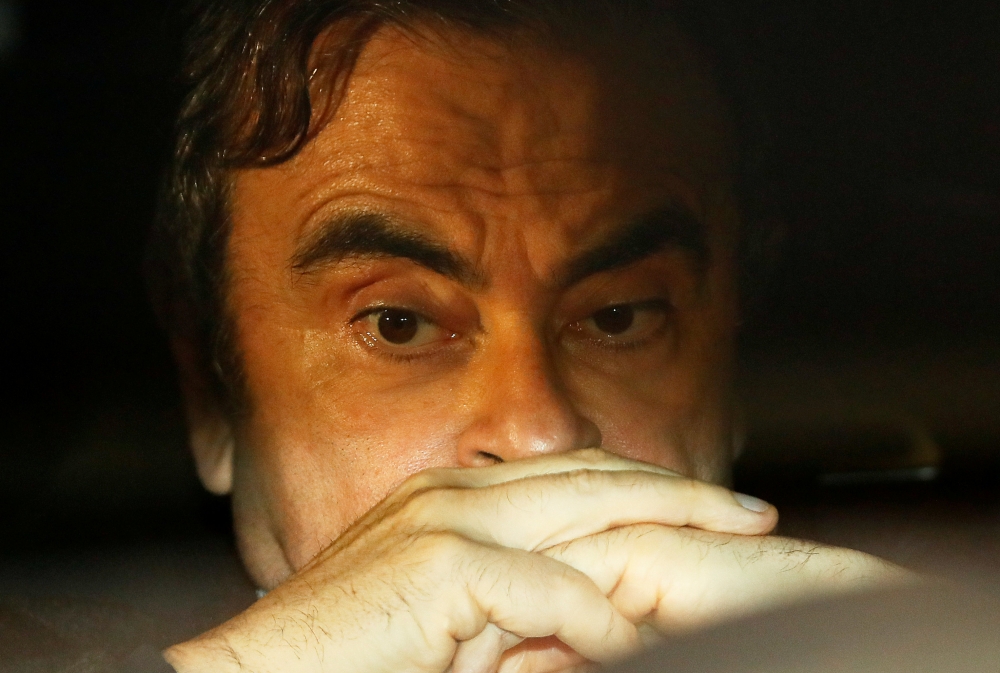File photo: Carlos Ghosn sits inside a car as he leaves his lawyers office after being released on bail from Tokyo Detention House, March 6, 2019. Reuters / Issei Kato