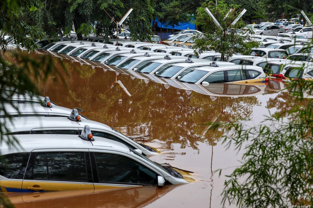 A fleet of flooded taxis are seen at the operator's submerged parking lot following overnight rain in Jakarta on January 1, 2020. Nine people died after Indonesia's capital was hit by its deadliest flooding in years, authorities said January 1, as torrent