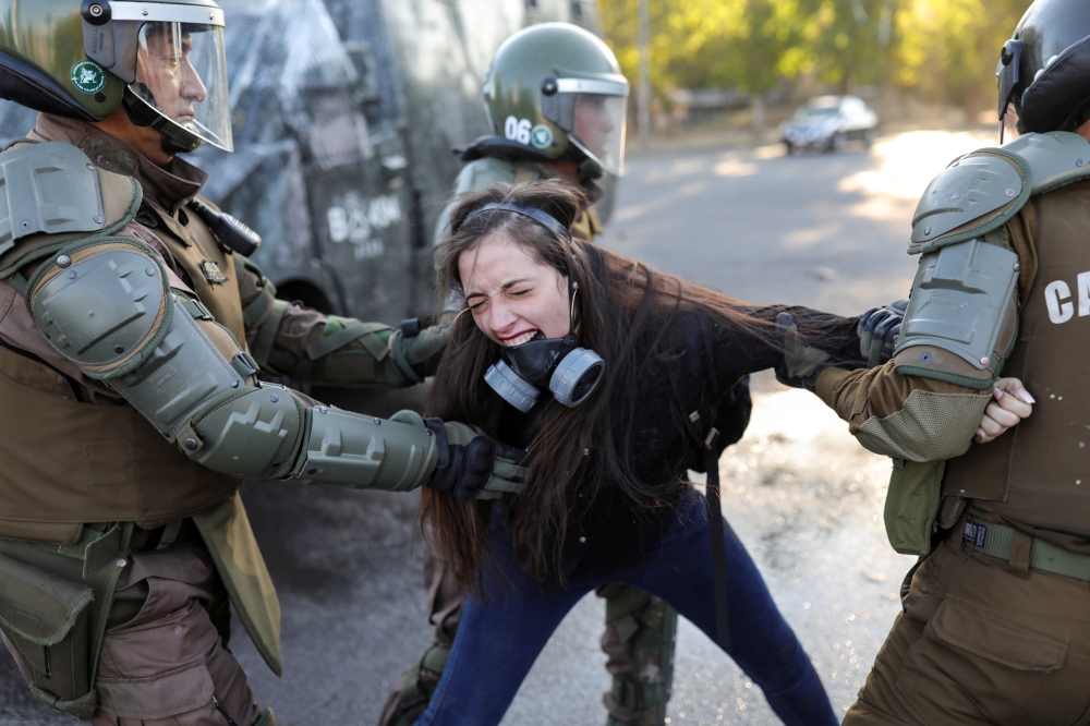 A demonstrator reacts as she is detained by riot policemen during a protest against Chile government in Santiago, Chile, November 30, 2019. Reuters / Pablo Sanhueza