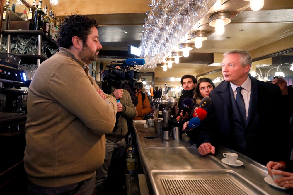 French Finance Minister Bruno Le Maire talks in a cafe as he visits shopkeepers, restaurateurs and hotel operators to assess the economic impact of nationwide strikes on pensions reform in Paris, France, January 3, 2020. Reuters/Charles Platiau 
