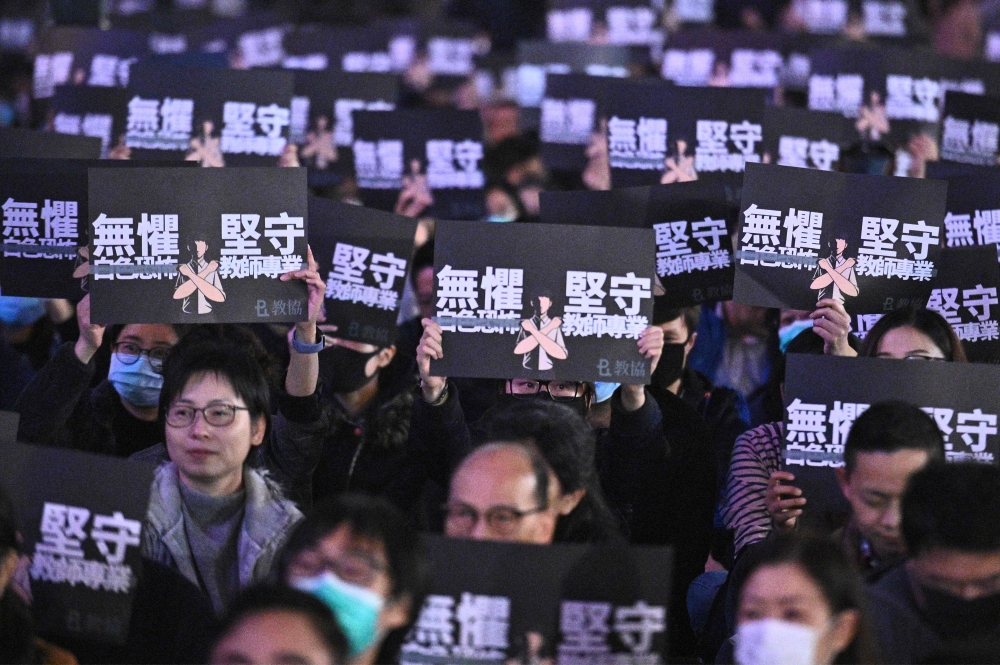 Teachers and pro-democracy supporters hold placards as they take part in a rally to support teachers at Edinburgh Place in the Central district of Hong Kong on January 3, 2020. AFP / Philip Fong