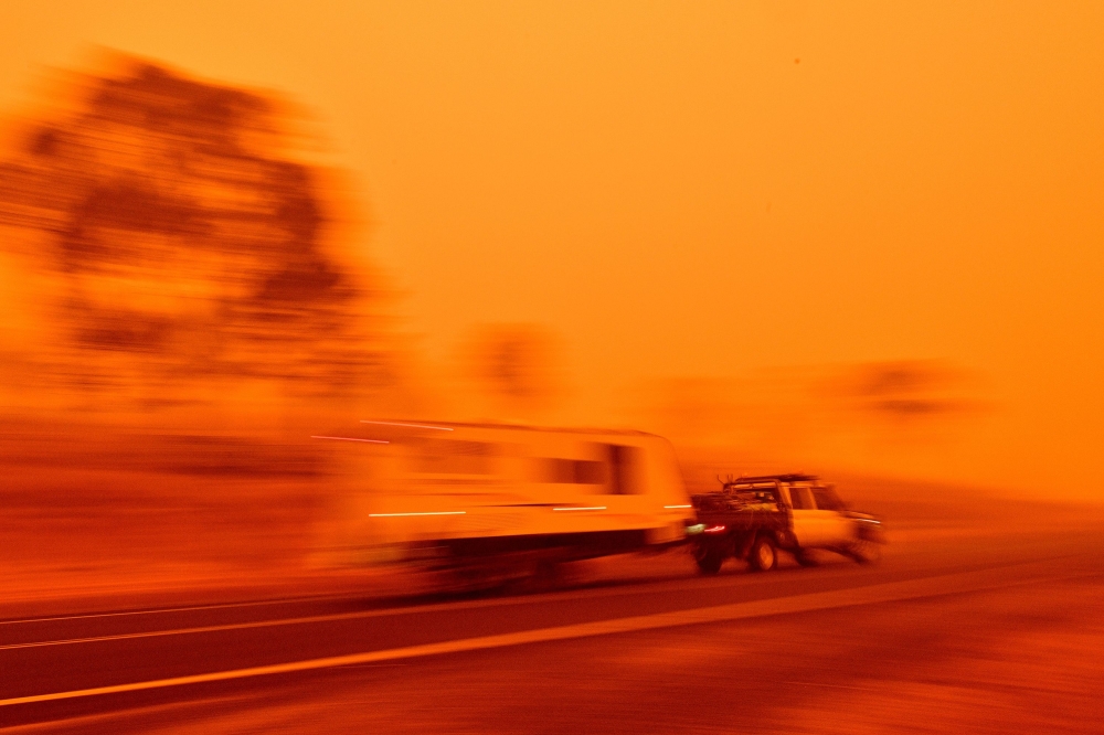 Residents commute on a road through thick smoke from bushfires in Bemboka, in Australia's New South Wales state on January 5, 2020. AFP / SAEED KHAN