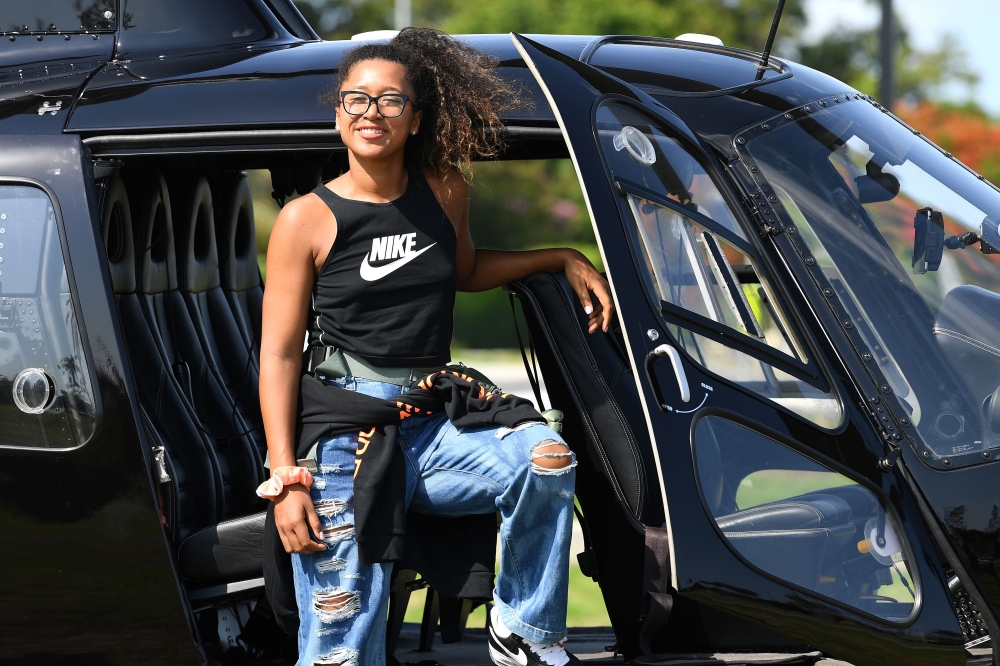 Tennis player Naomi Osaka of Japan poses for photos after a sightseeing ride in a helicopter at the Queensland Tennis Centre in Brisbane on January 2, 2020, ahead of the Brisbane International tennis tournament starting on January 6. AFP / Saeed Khan 
