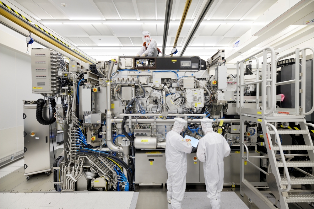Employees are seen working on the final assembly of ASML's TWINSCAN NXE:3400B semiconductor lithography tool with its panels removed, in Veldhoven, Netherlands, in this picture taken April 4, 2019. Bart van Overbeeke Fotografie/ASML/Handout via Reuters