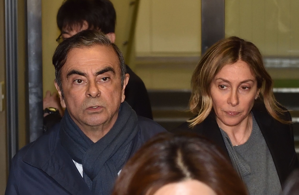 (FILES) This file photo taken on April 3, 2019 shows former Nissan chairman Carlos Ghosn (L) and his wife Carole (R) leaving the office of his lawyer in Tokyo. Prosecutors in Japan have obtained an arrest warrant for Carole Ghosn, wife of former Nissan ch