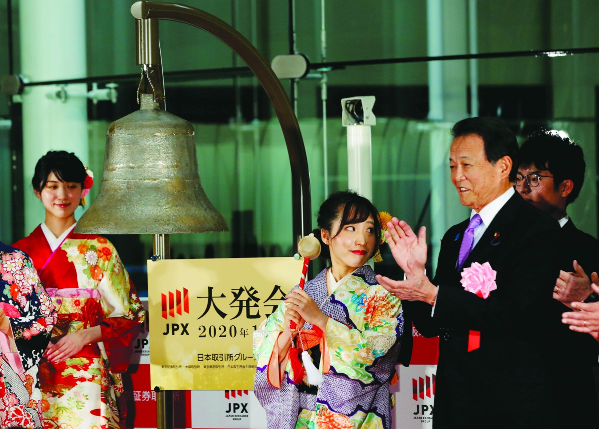 Japan's Deputy Prime Minister and Finance Minister Taro Aso applauds as a woman, dressed in ceremonial kimono, rings a bell during the New Year opening ceremony at the Tokyo Stock Exchange (TSE), held to wish for the success of Japan's stock market in Tok
