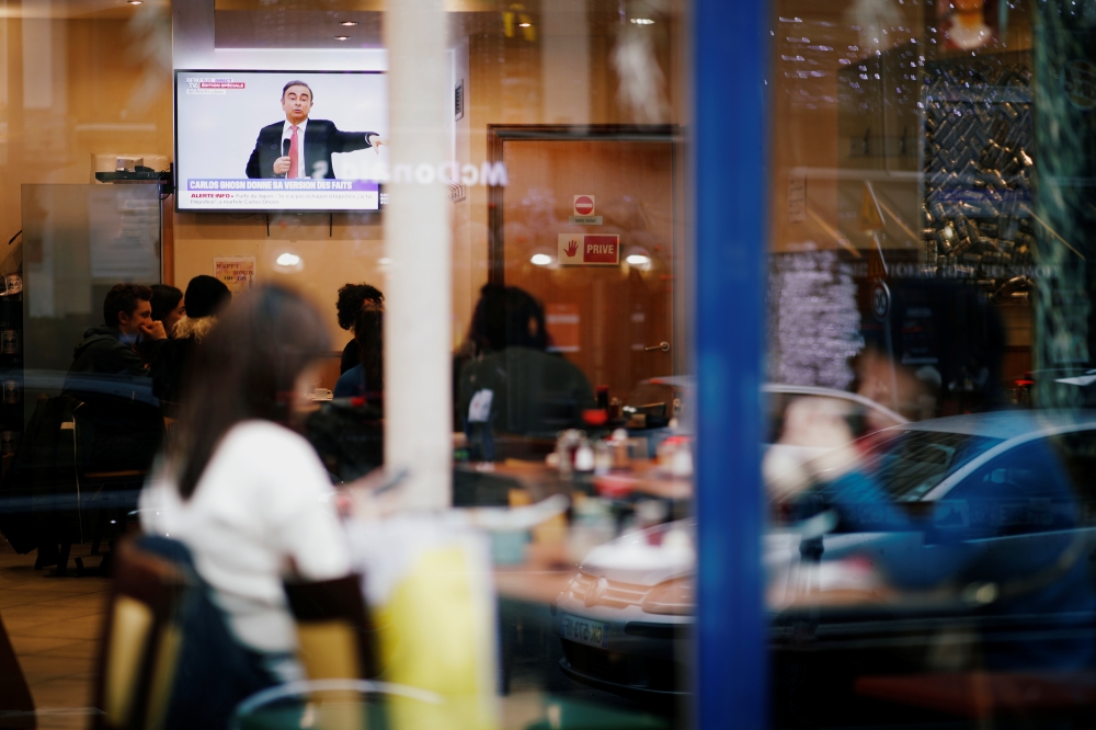 Customers at a Japanese restaurant watch on TV the live news conference of former Nissan chairman Carlos Ghosn in Paris, France January 8, 2020. Reuters/Benoit Tessier
 
