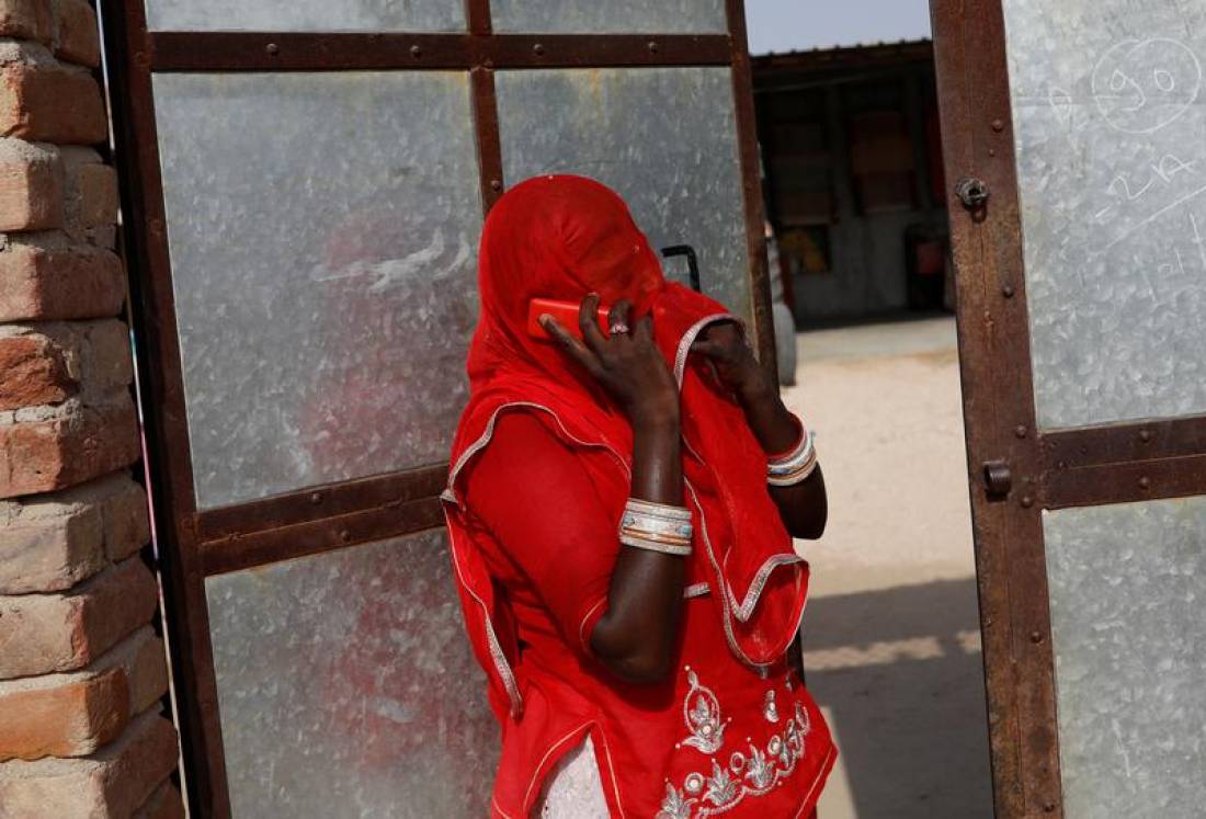 A woman speaks on the phone outside her house in a village in Jalore, India, April 11, 2018. Reuters/Danish Siddiqui