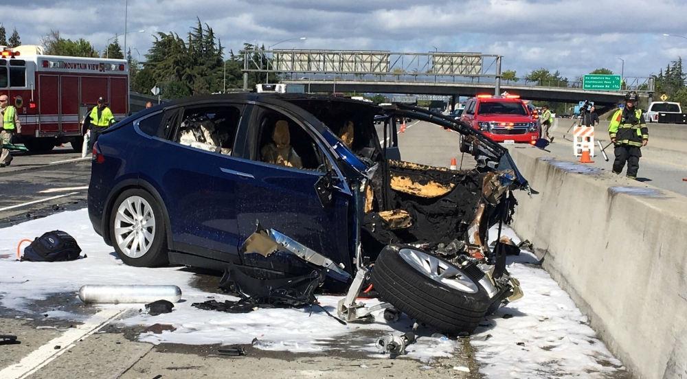 Rescue workers attend the scene where a Tesla electric SUV crashed into a barrier on US Highway 101 in Mountain View, California, March 25, 2018. (KTVU / Fox 2 via Reuters) 