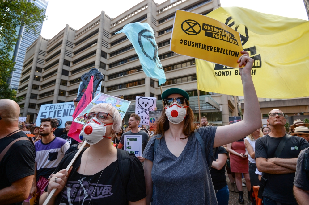 Protesters hold placards during a climate change rally in Sydney, Australia, January 10, 2020. AAP Image/Paul Braven/via REUTERS 