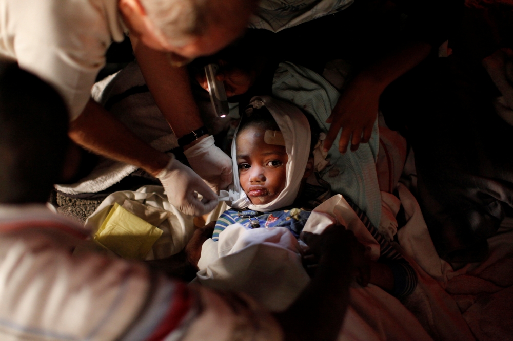 An injured child receives medical treatment after an earthquake in Port-au-Prince in this January 13, 2010 file photo. Reuters/Eduardo Munoz