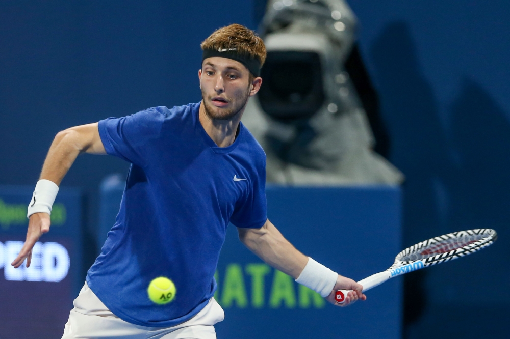 France's Corentin Moutet returns against Switzerland's Stan Wawrinka during their ATP Qatar Open semi-final tennis match in Doha, on January 10, 2020. (AFP / MUSTAFA ABUMUNES)