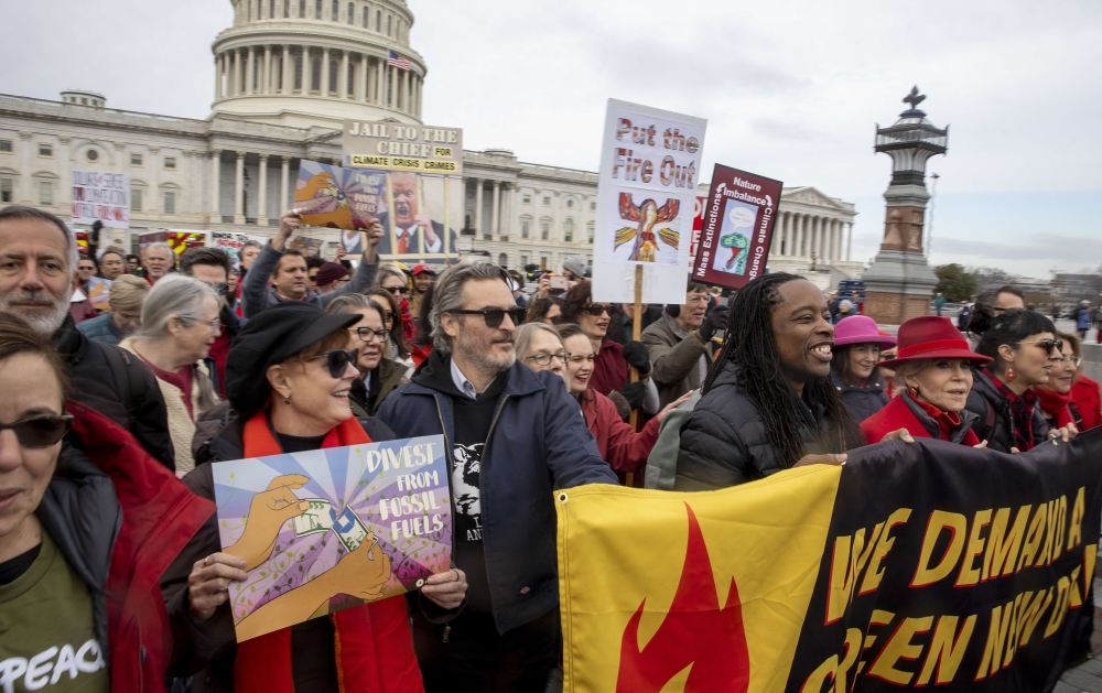Actor Joaquin phoenix (4L) and actress Susan Sarandon (2L) demonstrate during Fonda-Fire Drill Friday with actress Jane Fonda (R) outside the Capitol for the last time protesting fossil fuel companies in Washington, DC, on January 10, 2020. / AFP / JIM WA