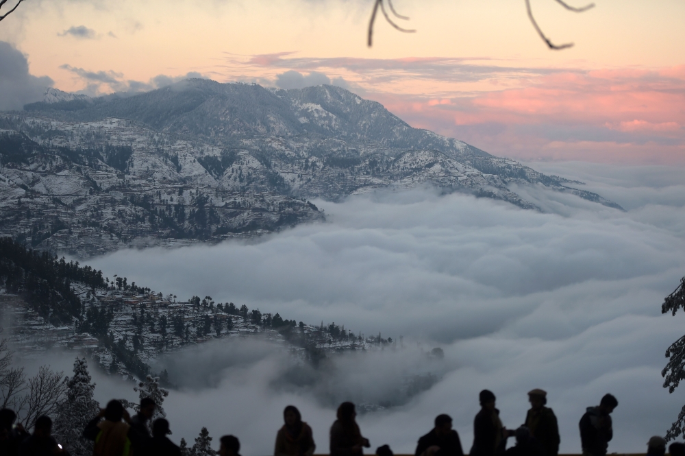 Tourist gather at a view point during a snowfall in Murree, some 65 km north of Islamabad on January 7, 2020. / AFP / Aamir QURESHI 