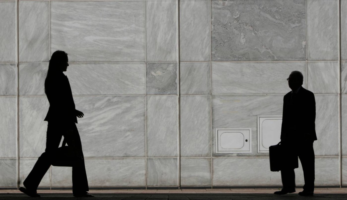 People are silhouetted at Canary Wharf business district in London May 1, 2007. Reuters/Luke MacGregor