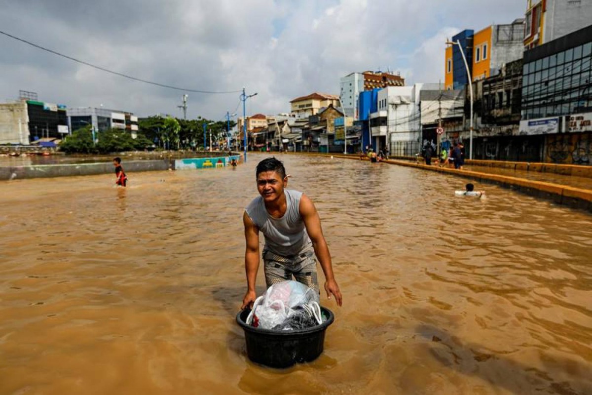 Man carries his belongings across floodwaters at the Jatinegara area after heavy rains in Jakarta, Indonesia, January 2, 2020. Reuters/Willy Kurniawan