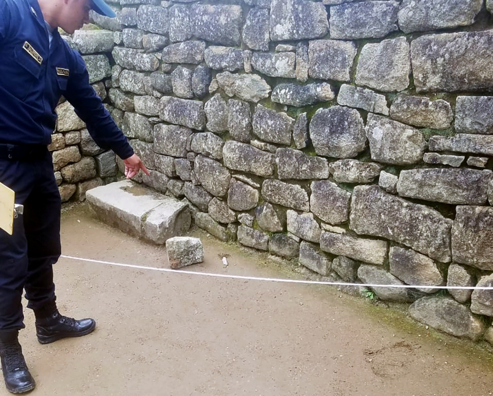 Handout image distributed by the Peruvian Police of a policeman showing a rock dislodged by a group of foreign tourists when trespassing to the ancient Inca citadel of Machu Picchu, Peru, on January 12, 2020/ AFP / Peruvian National Police /