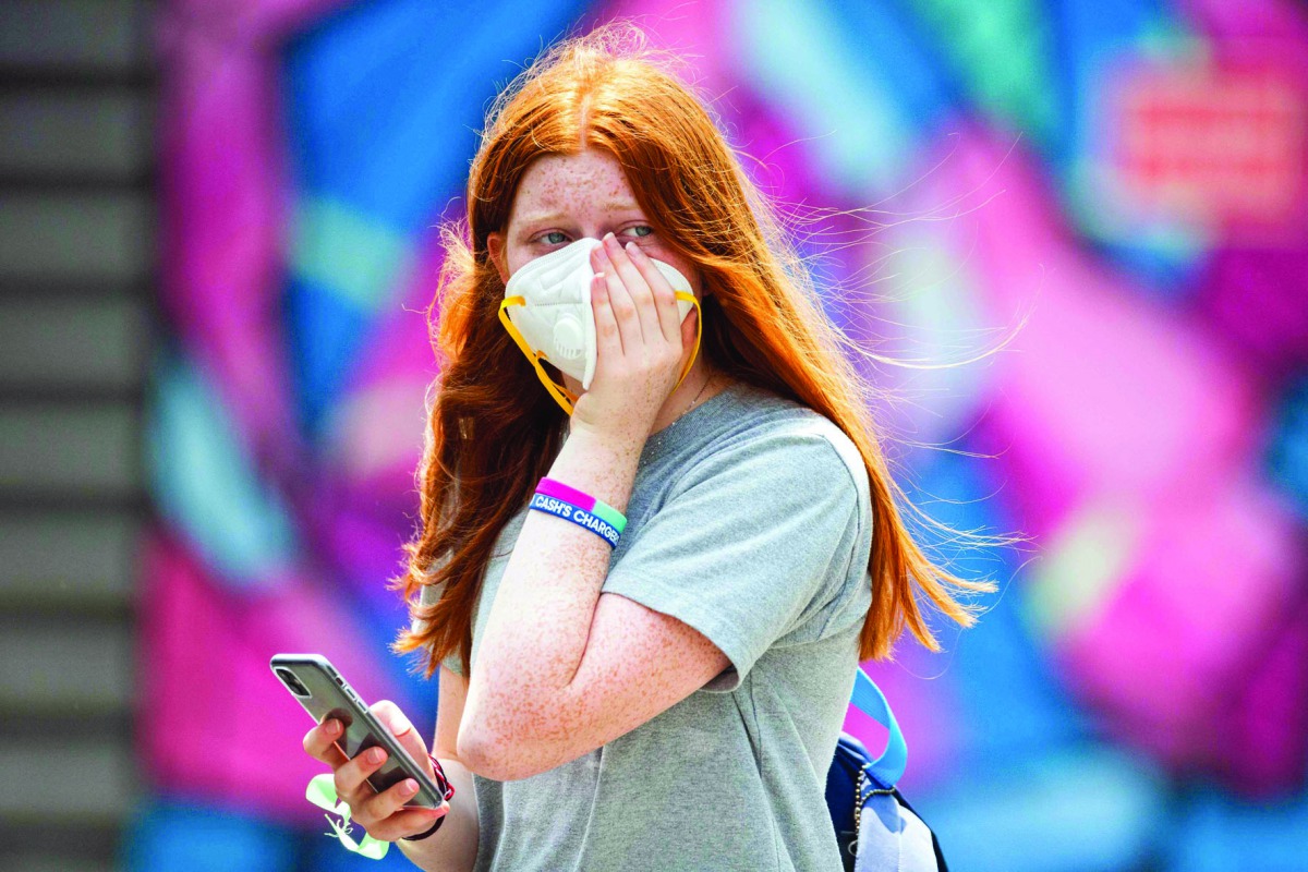 A woman holds onto her face mask during a practice session in Melbourne on January 15, 2020, ahead of the Australian Open tennis tournament. AFP / Asanka Brendon Ratnayake