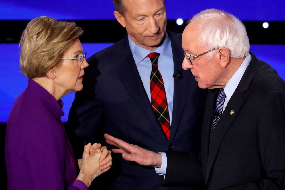 FILE PHOTO: Democratic 2020 U.S. presidential candidates (L-R) Senator Elizabeth Warren (D-MA) speaks with Senator Bernie Sanders (I-VT) as billionaire activist Tom Steyer listens after the seventh Democratic 2020 presidential debate at Drake University i