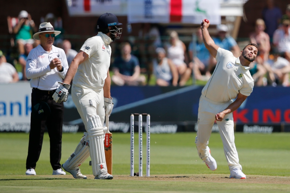 South Africa's Dane Paterson (R) delivers a ball to England's Dom Sibley as England's Zak Crawley (C) and umpire Bruce Oxenford (L) looks on during the first day of the third Test cricket match between South Africa and England at the St George's Park Cric