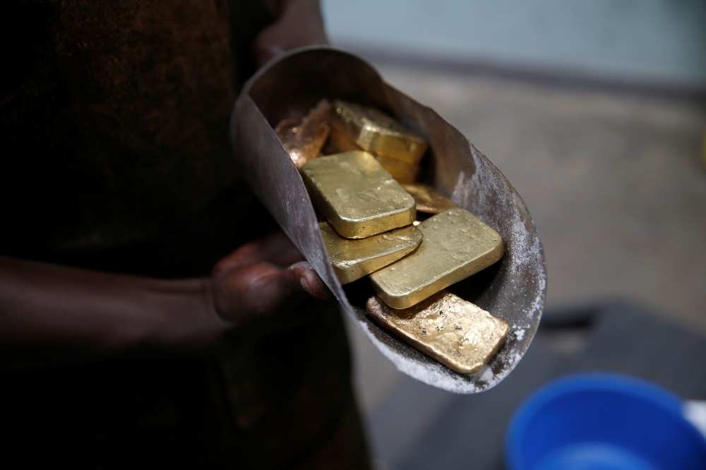 An employee holds gold bars before the refining process at African Gold Refinery in Entebbe, Uganda, October 4, 2018. Reuters/Baz Ratner