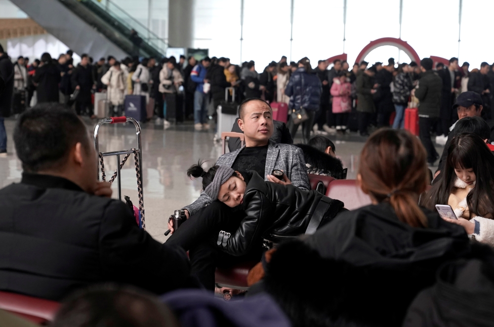 Travellers wait for their trains inside Zhengzhou East Railway Station during the annual Spring Festival travel rush ahead of the Chinese Lunar New Year, in Zhengzhou, Henan province, China January 13, 2020. Picture taken January 13, 2020. REUTERS/Jason L