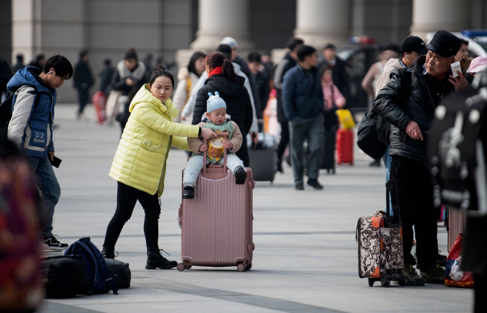 Passengers arrive at a train station in the city of Wuhan in Hubei province on January 12, 2020. AFP / Noel Celis
