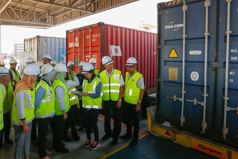 Malaysian officials inspect a container containing plastic waste shipment on January 20, 2020 before sending back to the countries of origin in Butterworth. - Malaysia OUT / AFP /