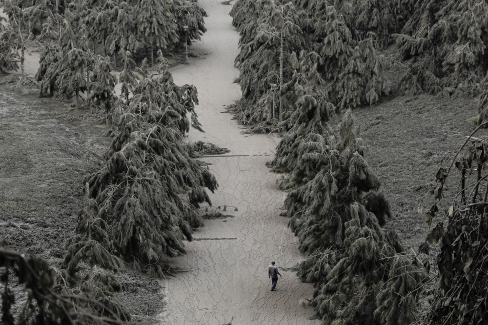 A man walks on a road blanketed with volcanic ash from the erupting Taal Volcano in Tagaytay, Philippines, January 14, 2020. REUTERS/Eloisa Lopez TPX IMAGES OF THE DAY