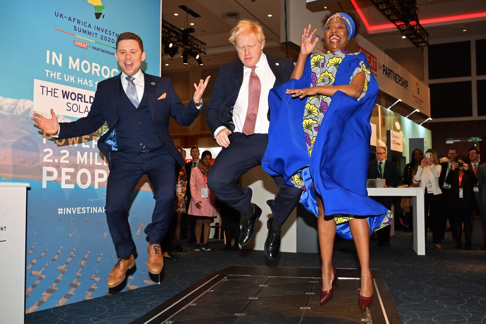 Britain's Prime Minister Boris Johnson (C), reacts as he visits the Pavegen's stand, a company that converts footsteps into energy, in the Innovation Zone at the UK-Africa Investment Summit in London on January 20, 2020. AFP Pool / Leon Neal
 