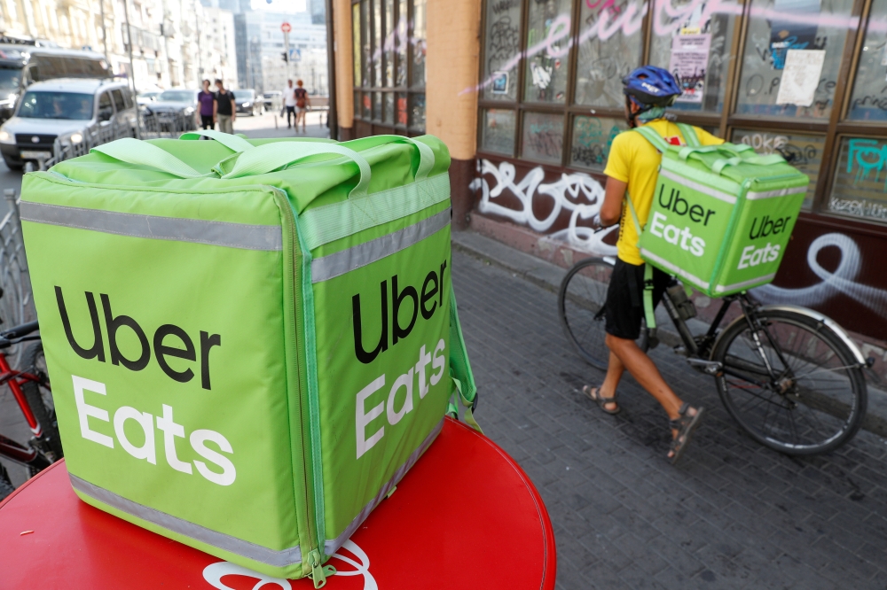 An Uber Eats food delivery courier pulls a bicycle in central Kiev, Ukraine. (REUTERS/Valentyn Ogirenko/File Photo)