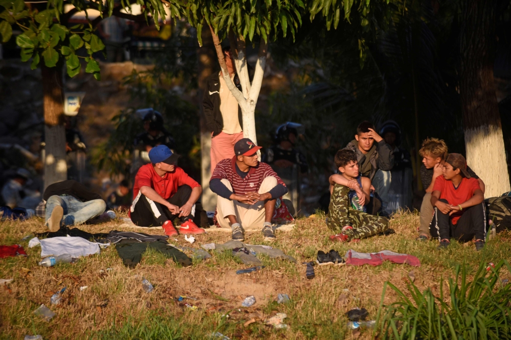 Central American migrants -mostly Hondurans heading in a caravan for the US- rest on the bank of the Suichate River, where they spent the night, in Ciudad Hidalgo, Mexico, after crossing from Tecum Uman, Guatemala, on January 21, 2020. AFP / Johan Ordonez