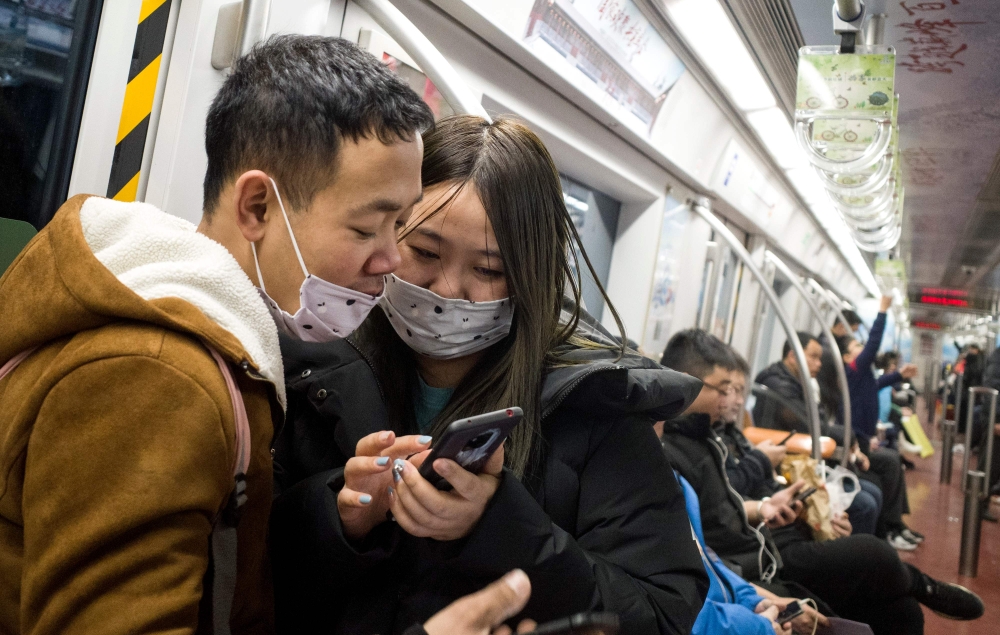 Subway passengers wear protective masks in Beijing on January 21, 2020. AFP / NOEL CELIS