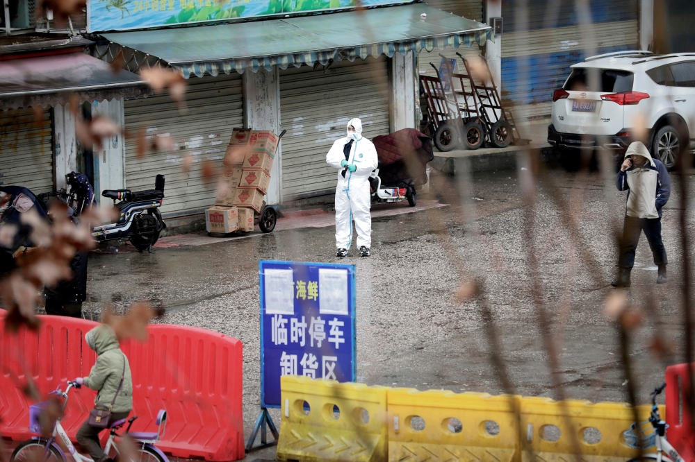 FILE PHOTO: A worker in a protective suit is seen at the closed seafood market in Wuhan, Hubei province, China January 10, 2020. Reuters/Stringer/File Photo CHINA OUT.