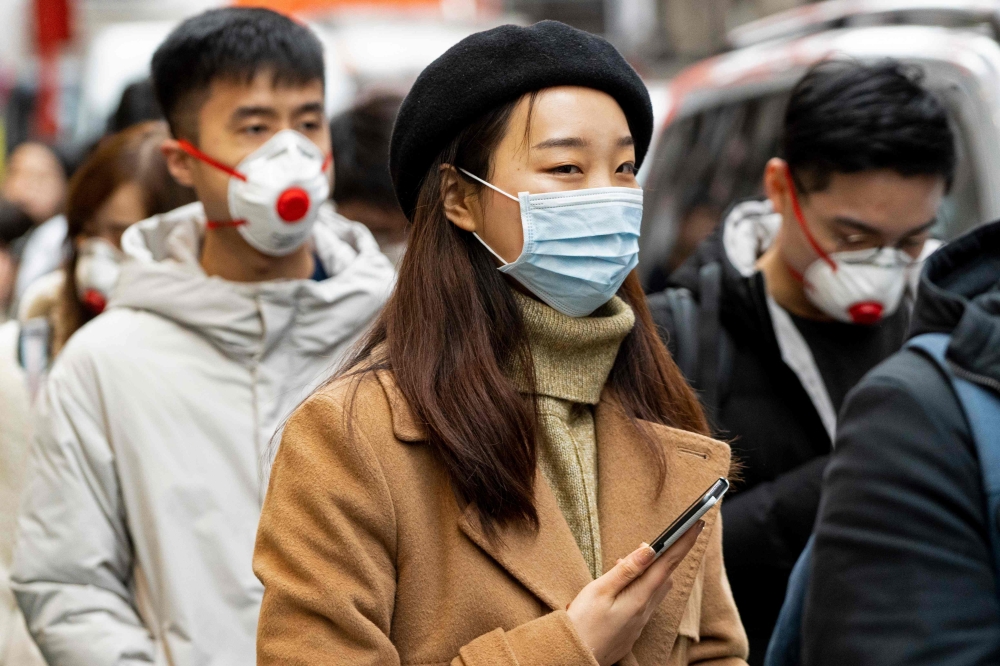 Pedestrians are seen wearing a surgical masks in London's China Town on January 25, 2020. AFP / Niklas Halle'n