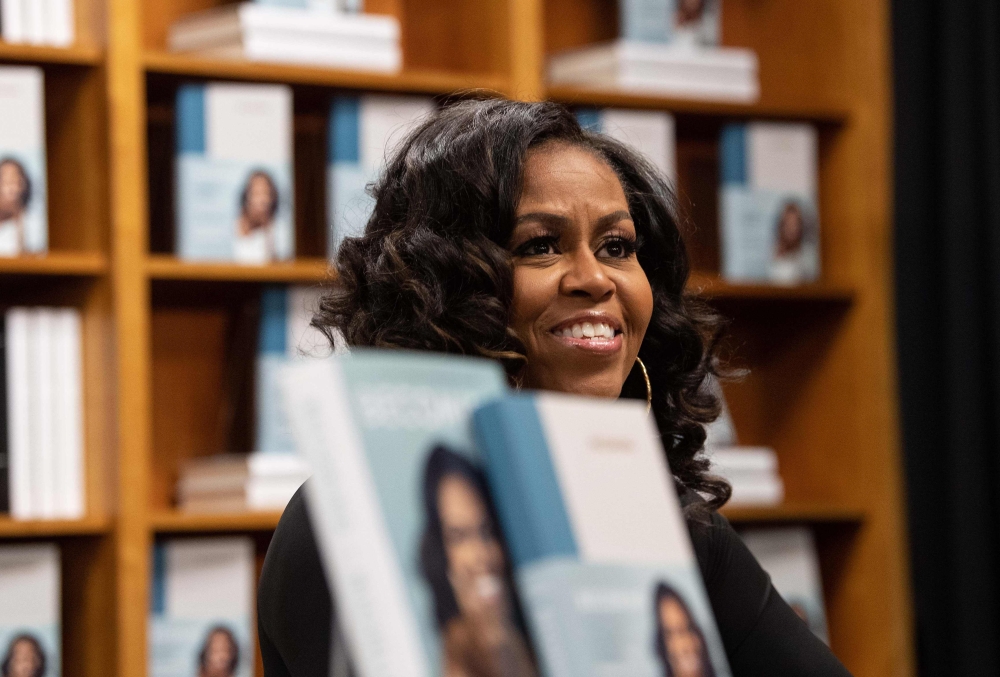 In this file photo taken on November 18, 2019 former US first lady Michelle Obama meets with fans during a book signing on the first anniversary of the launch of her memoir 