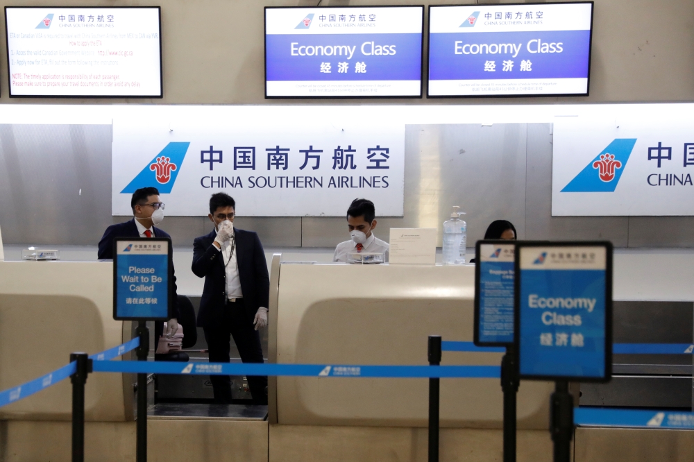 China Southern Airlines employees wear a surgical mask as a preventive measure in light of the coronavirus outbreak in China, as they wait for customers behind the counter at Benito Juarez international airport in Mexico City, Mexico January 28, 2020. REU