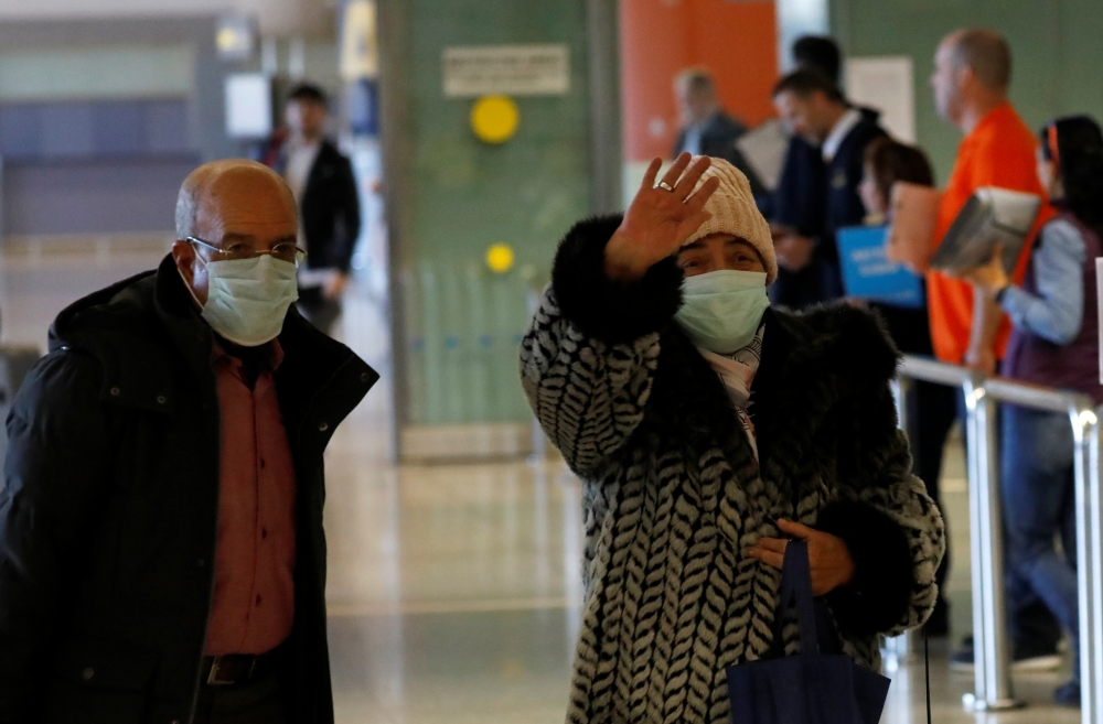 Tourists from Morocco wear masks to prevent contracting coronavirus at the Malaga-Costa del Sol airport, in Malaga, southern Spain January 29, 2020. REUTERS/Jon Nazca