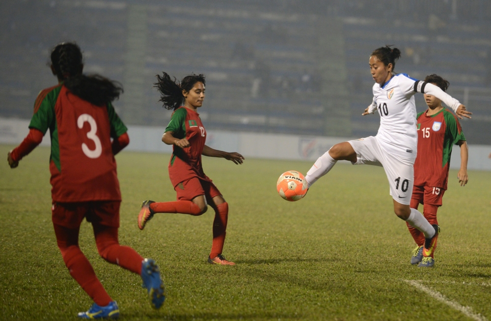 In this file photo taken on January 04, 2017 India's Ngangom Bala Devi (R) fights for the ball with Bangladesh players during the final of the South Asian Football Federation (SAFF) women's football championship at the Kanchanjungha Stadium in Siliguri./ 